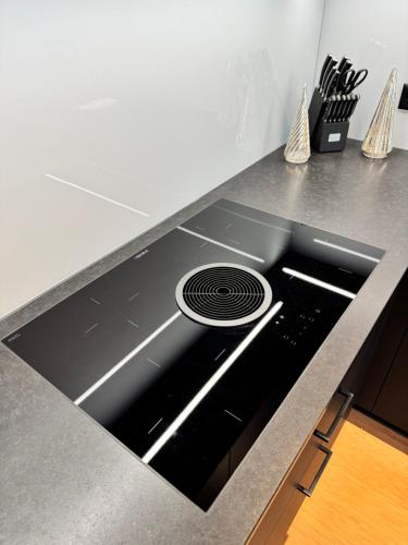 a kitchen counter with a black stove top oven at Römer Apartment in Kaiseraugst