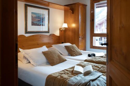 a hotel room with two beds with books on them at Résidence Pierre & Vacances Premium Arc 1950 Le Village in Arc 1950
