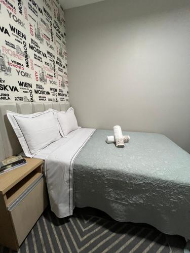 a bed with a teddy bear sitting on top of it at Loft Home Vila Bella in Cuiabá