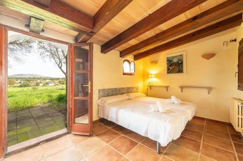 a bedroom with a bed and a sliding glass door at Finca Son Xona in Capdepera