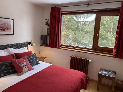 ein Schlafzimmer mit einem Bett mit einer roten Decke und einem Fenster in der Unterkunft Courchevel 1850 in Courchevel