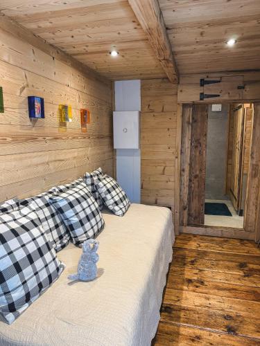 un ours en peluche assis sur un lit dans une cabine dans l'établissement Mazot du Criou - Samoëns, à Samoëns