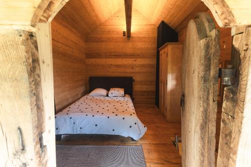 1 dormitorio pequeño en una cabaña de madera con 1 cama en Mazot du Criou - Samoëns, en Samoëns