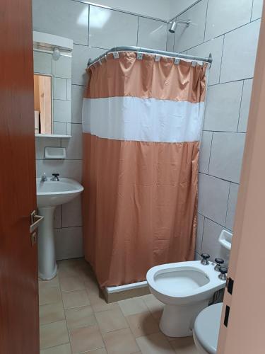een badkamer met een douchegordijn en een toilet bij Santa Ana Alojamiento in Puerto Madryn