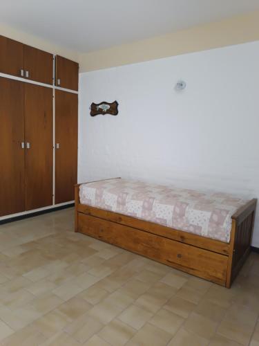 een slaapkamer met een bed in de hoek van een kamer bij Santa Ana Alojamiento in Puerto Madryn