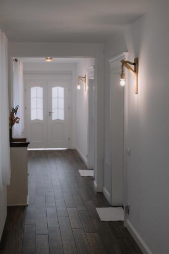an empty hallway with white walls and wood floors at Chalet Odette in Pangarati