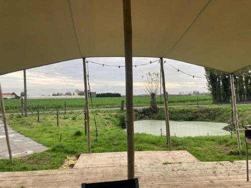 a large tent with a view of a field at Tiny House 't klein geluk dichtbij Brugge met fiets' in Wingene