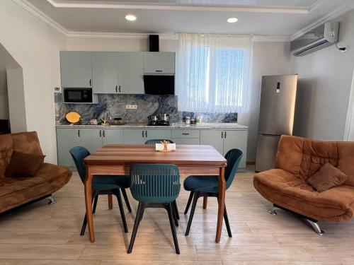 a kitchen with a wooden table and chairs in a room at GT House Batumi in Batumi