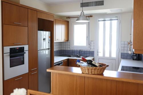 a kitchen with wooden cabinets and a counter top at KomiVillas in Lilikás