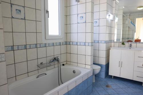 a white bathroom with a tub and a toilet at KomiVillas in Lilikás