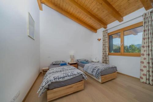 a bedroom with two beds and a window at Sun Villa in Càneva