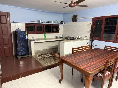 a kitchen with a wooden table and a stove at Ritu Homestay (The Second Wind) in Trivandrum
