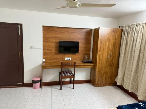 a room with a desk with a tv and a chair at Ritu Homestay (The Second Wind) in Trivandrum