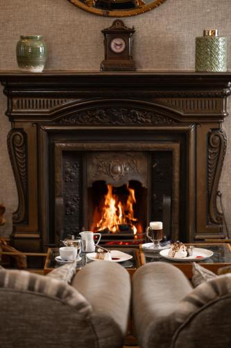 a living room with a fireplace with a fire in it at Jackson's Hotel & Leisure Centre in Ballybofey