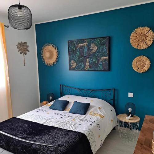 une chambre avec un mur bleu avec un lit dans l'établissement Maison charmante à Saint-Pierre-de-Clairac avec piscine privée, à Saint-Pierre-de-Clairac