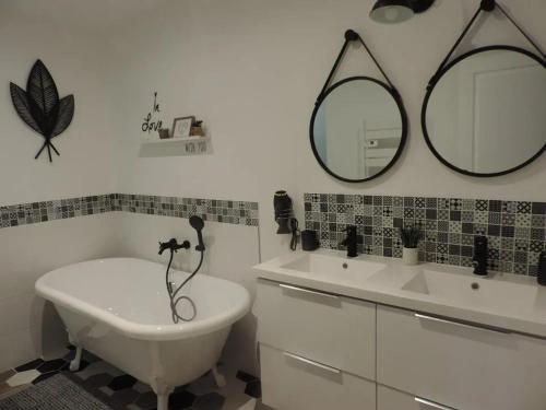 La salle de bains est pourvue d'une baignoire, d'un lavabo et d'un miroir. dans l'établissement Maison charmante à Saint-Pierre-de-Clairac avec piscine privée, à Saint-Pierre-de-Clairac