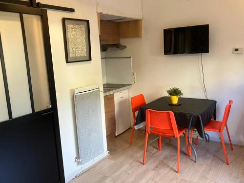 une salle à manger avec une table et des chaises rouges dans l'établissement Le Merle Rose, à Toulouse
