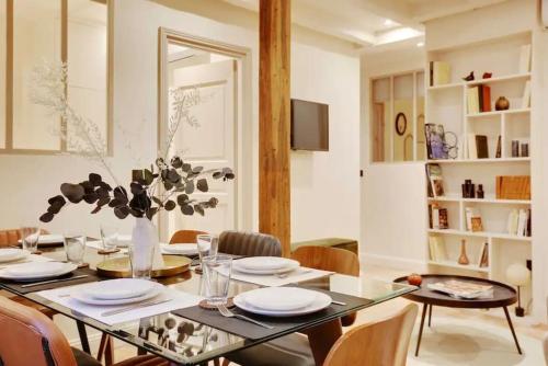 une table de salle à manger avec un vase de fleurs dessus dans l'établissement J Wonderful flat in Le Marais, à Paris