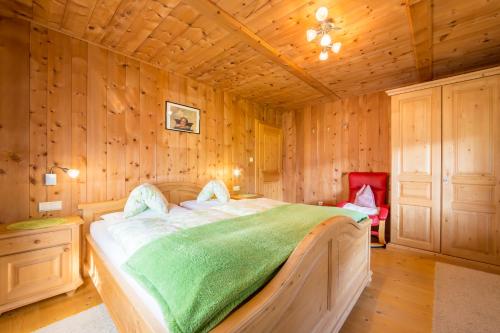 a bedroom with a bed in a wooden room at Obermarhof Gsies in Prateria