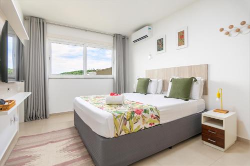 una camera da letto con un letto grande e una finestra di Vista de Cinema Praia da Armação dos Búzios a Búzios