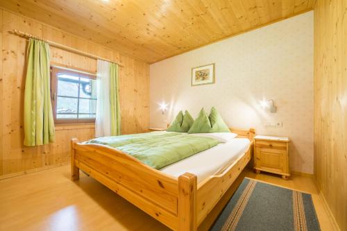 a bedroom with a wooden bed in a room at Obermarhof Gsies in Prateria