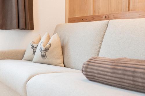 a white couch with two pillows on it at Obermarhof Gsies in Prateria