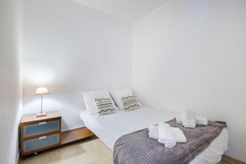 - une chambre blanche avec un lit et une table de nuit dans l'établissement Superbe Appart rue d'Italie, à Nice