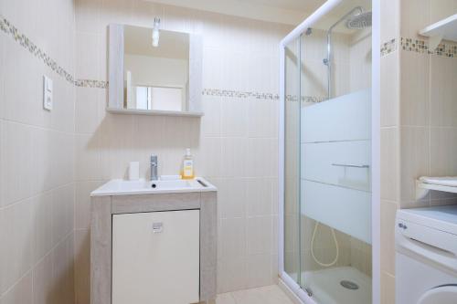 une salle de bain blanche avec un lavabo et une douche dans l'établissement Superbe Appart rue d'Italie, à Nice