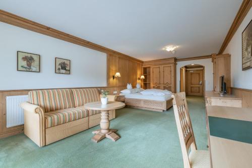 a hotel room with a couch and a table at KERSCHDORFER - wohlfühlhotel garni - adults only in Kaltenbach