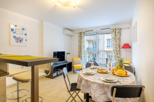 une cuisine et une salle à manger avec une table et des chaises dans l'établissement Superbe Appart rue d'Italie, à Nice