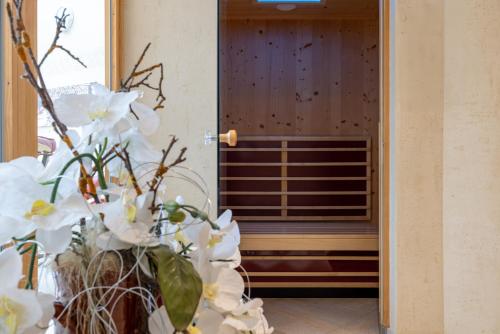 a vase of white flowers in front of a door at KERSCHDORFER - wohlfühlhotel garni - adults only in Kaltenbach