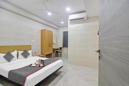 a hotel room with a bed and a table at Super Townhouse Ameerpet in Hyderabad