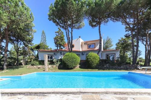 a villa with a swimming pool in front of a house at Vita Portucale ! Sintra Retreat Villa with Pool in Sintra