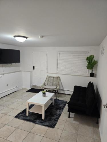 a living room with a black couch and a table at Cozy Apartment in Halifax