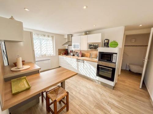 - une cuisine avec une table en bois et une cuisinière four supérieur dans l'établissement Jardin - Parking - 10 min Centre Ville, à Sanary-sur-Mer
