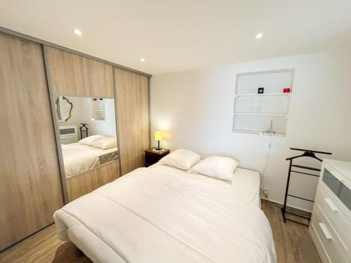 une chambre avec un grand lit blanc et un miroir dans l'établissement Jardin - Parking - 10 min Centre Ville, à Sanary-sur-Mer