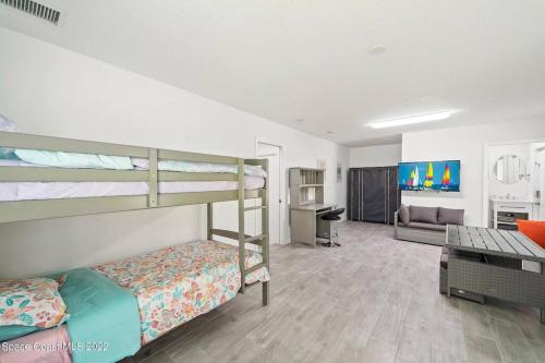a bedroom with two bunk beds and a living room at Sea View in Melbourne Beach