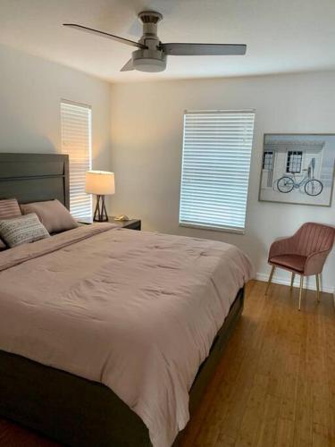 a bedroom with a large bed with a ceiling fan at Sea View in Melbourne Beach
