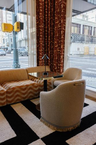 a living room with a couch and chairs and a table at voco Hotel Napoleon Memphis by IHG in Memphis