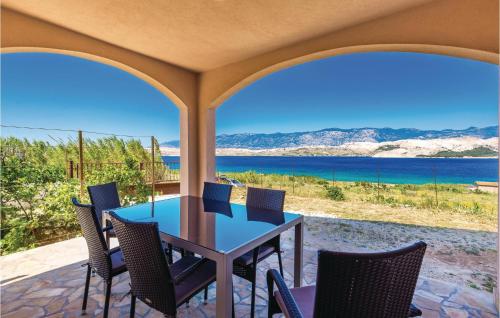 stół i krzesła na tarasie z widokiem na ocean w obiekcie Holiday Home Pag 5 w mieście Pag