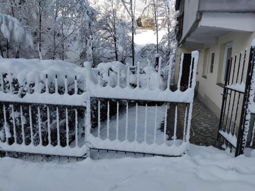 a fence covered in snow next to a house at Bazen in Sarajevo