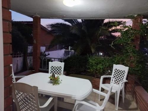 a white table and chairs on a patio at Casa y cabaña de Gachy in Villa Carlos Paz
