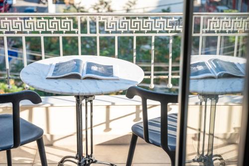a table with an open book on it next to two chairs at eleVSis 1 in Elefsina