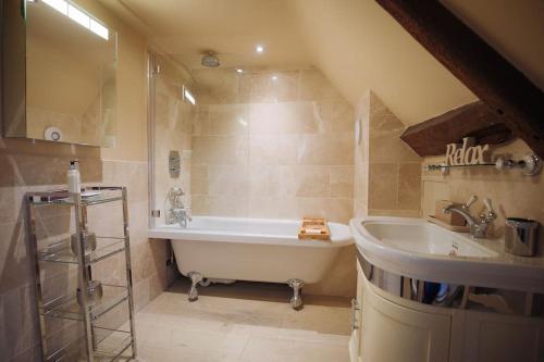 a bathroom with a tub and a sink at 5 bedroom Manor with idyllic countryside views in Croxton Kerrial