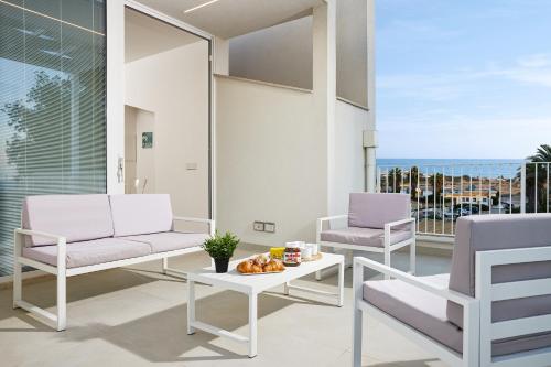 a living room with two chairs and a table at Keys of Sicily - Residence "Sabbia" sul mare in Marina di Modica
