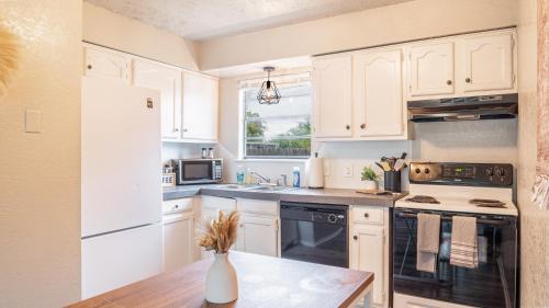 a kitchen with white cabinets and a black appliance at Tendayis Paradise in Abilene
