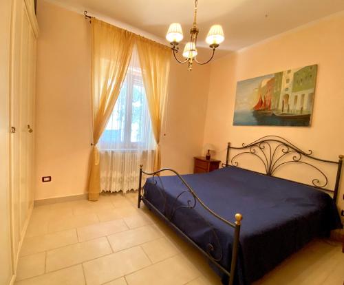 Un dormitorio con una cama azul y una ventana. en Yogargano, en Monte SantʼAngelo