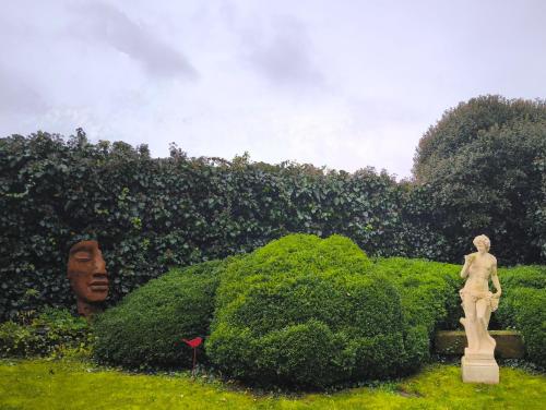 une statue dans un jardin avec une grande tête dans l'établissement Le Jardin Villemaurine, à Saint-Émilion