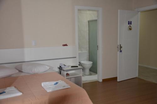 um quarto com uma cama e uma casa de banho com um WC em Hotel Alpen Hof em Gramado
