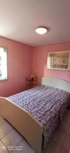 - une chambre avec un grand lit dans un mur rouge dans l'établissement la pépite du cap d'agde, au Cap d'Agde